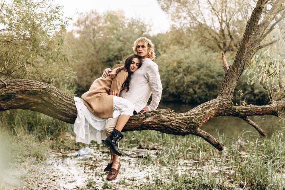 A couple sitting on a large tree branch