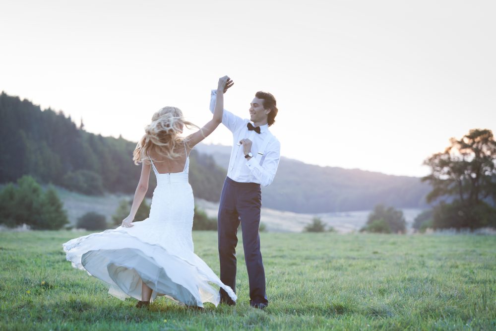Bride and groom dancing in the middle of a field