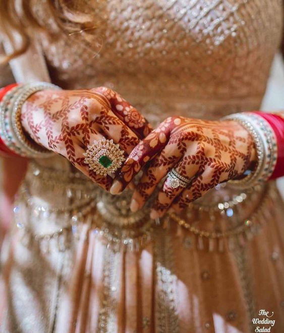 hand with henna wearing engagement ring