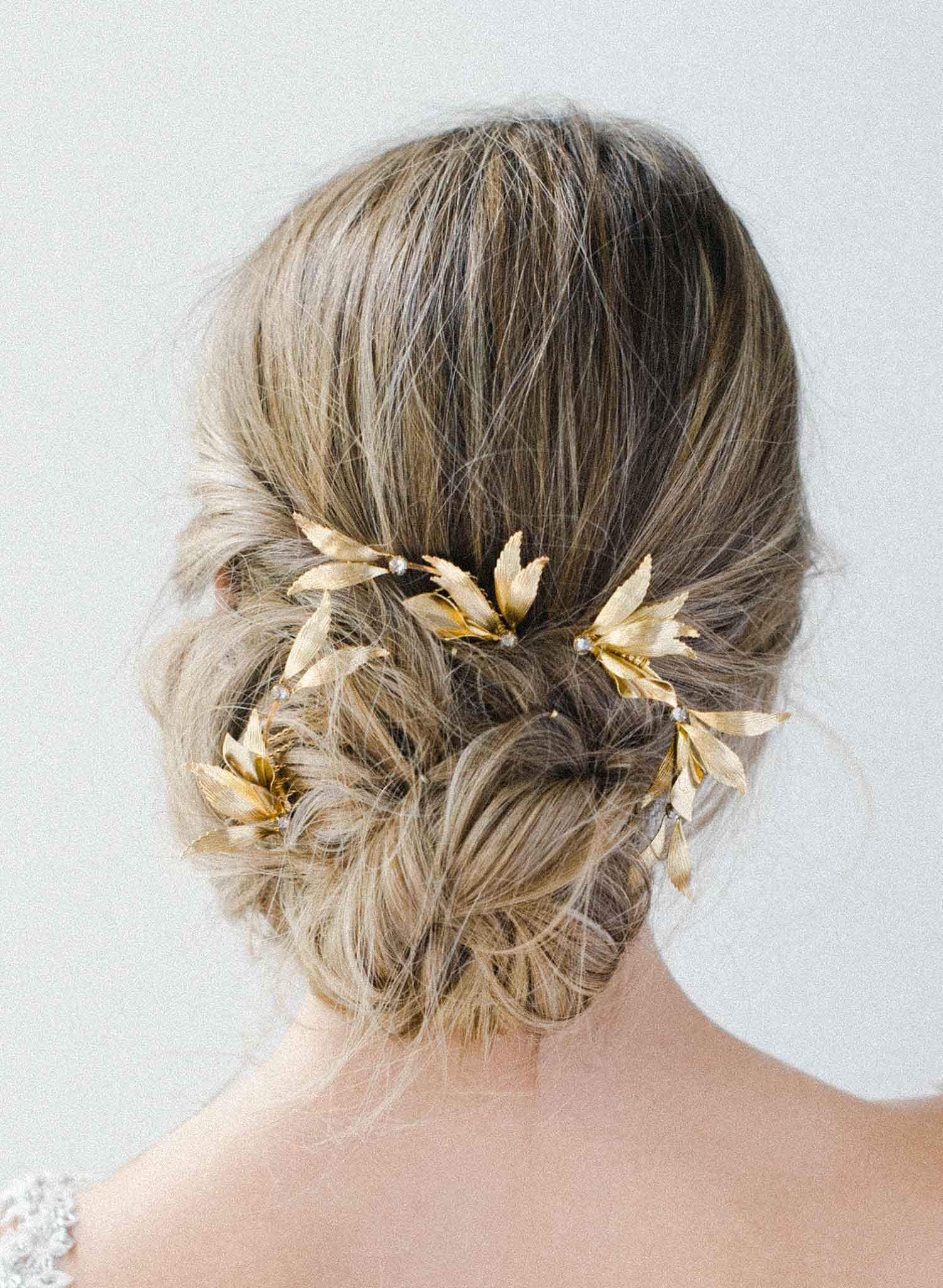 Bride wearing gilded floral branch pin accessory