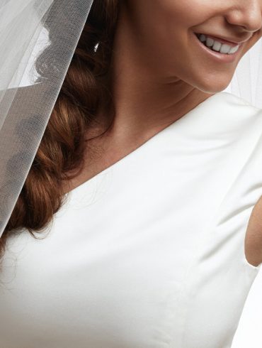 Smiling bride showing off her one should strap dress