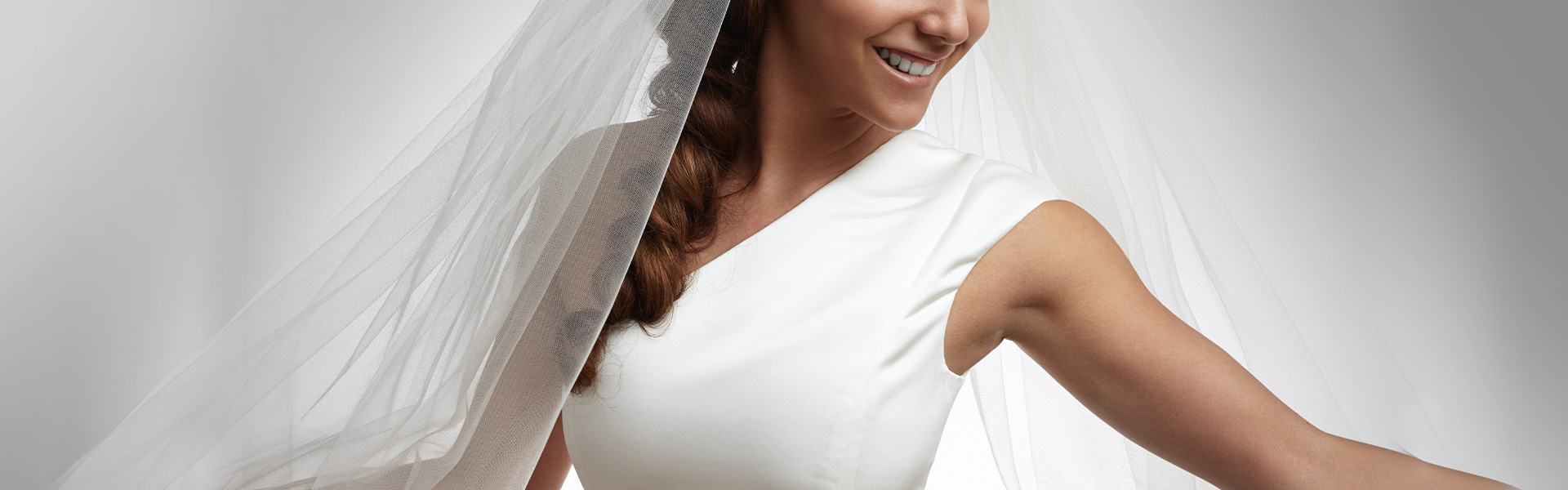 Smiling bride showing off her one should strap dress