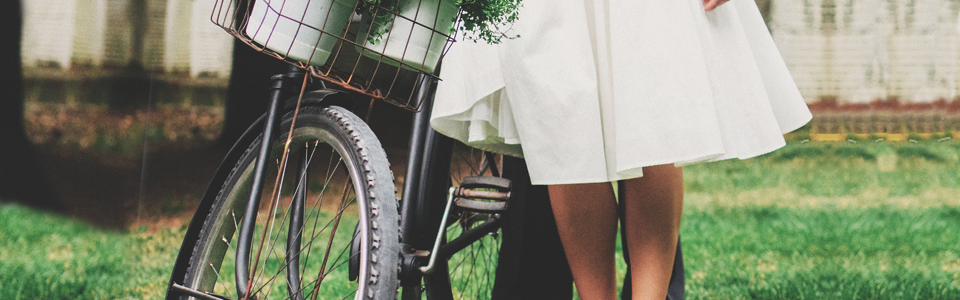 Photo of bride and grooms legs, standing by a bike