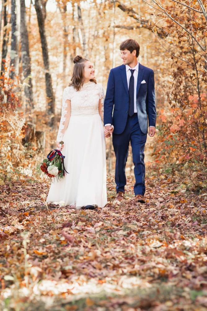 Bride and groom walking in autumn forest