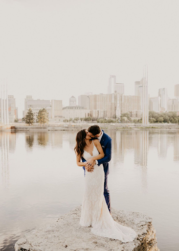 Newly weds kissing with a city skyline as a backdrop