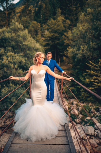 Bride and groom take picturesque photo on bridge