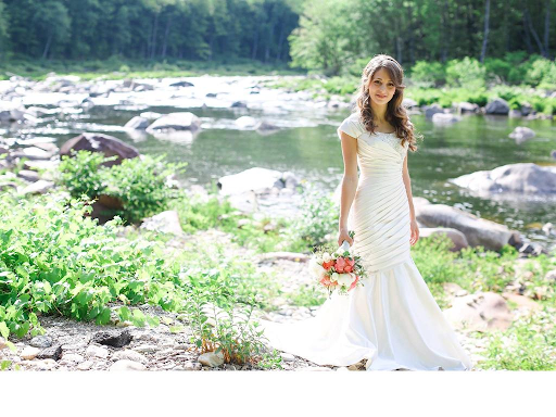 Bride showing off dress by a river