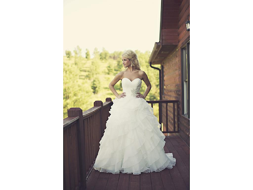 Bride in strapless dress looking over the balcony of a log cabin