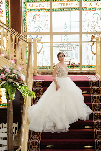 Bride taking photo on the stairs of her wedding venue