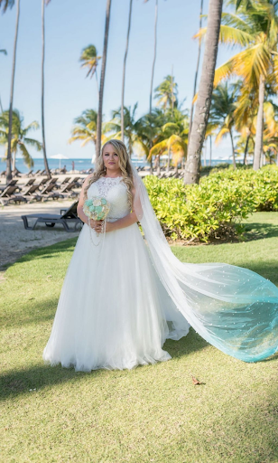 Bride showing off her wedding dress by the beach