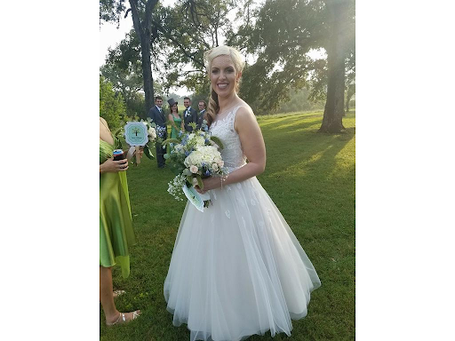 Happy bride holding flowers in a park