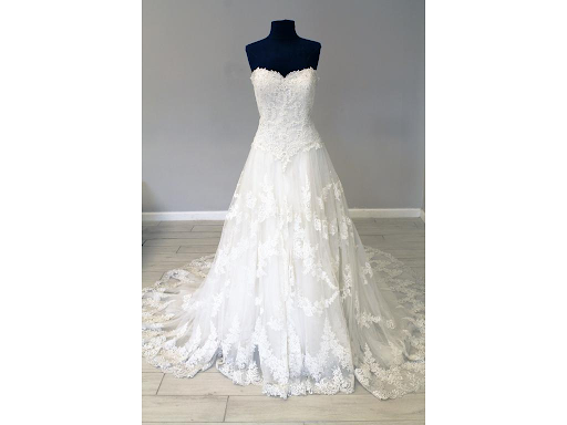 White wedding dress on display with distinct basque waistline