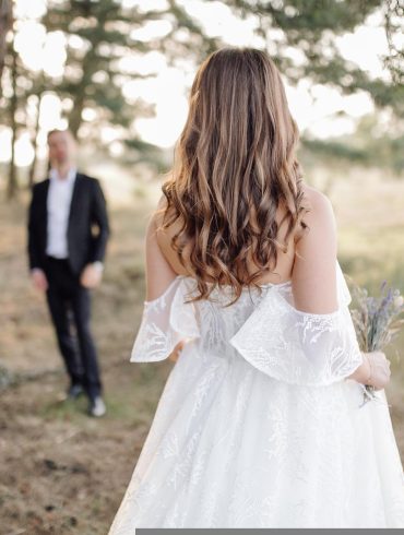 Recently married bride wearing her wedding dress with groom in background