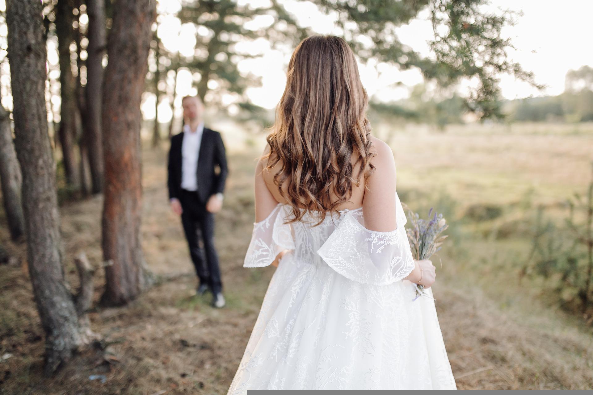 Recently married bride wearing her wedding dress with groom in background