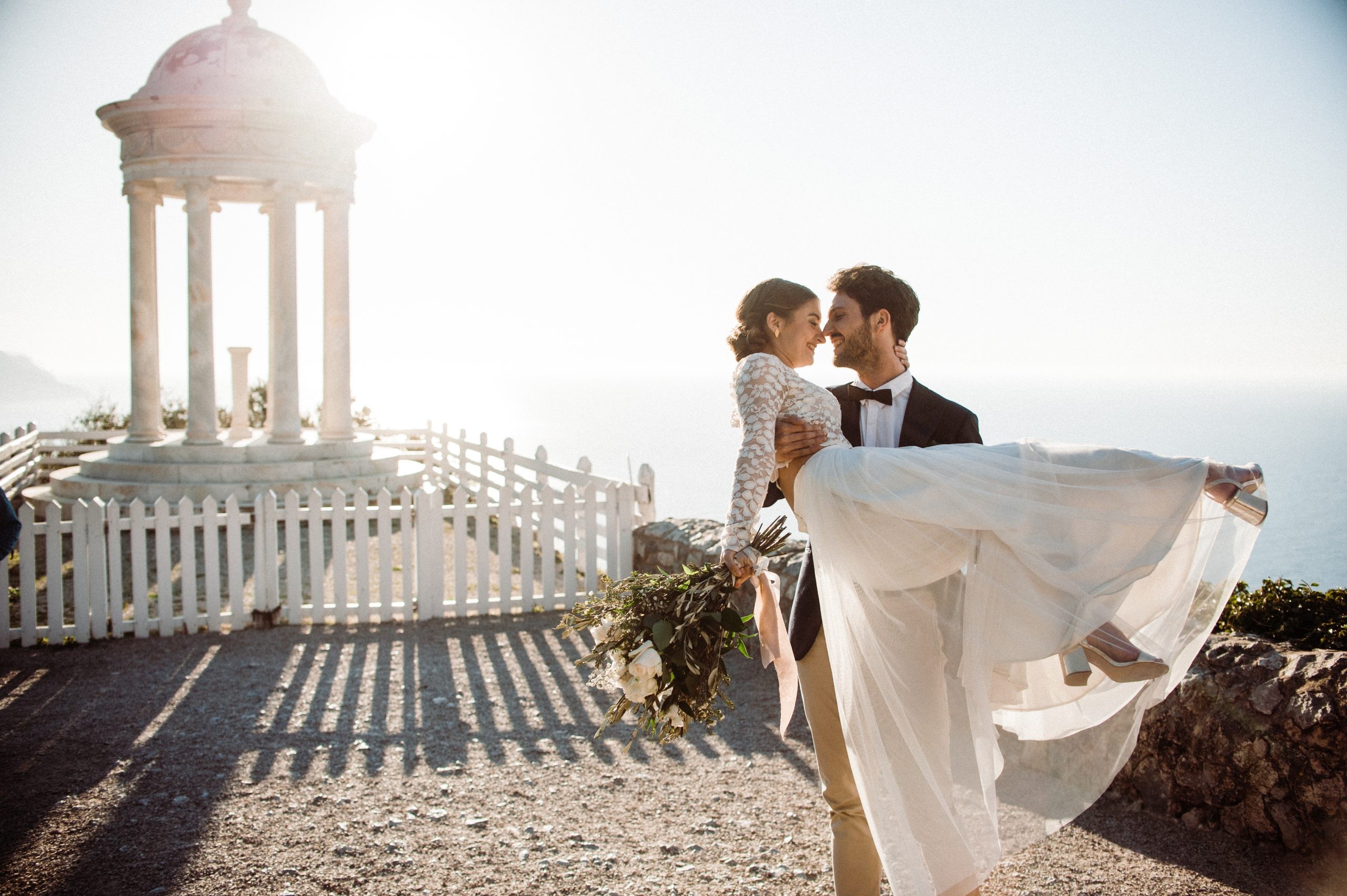 Groom holding bride in romantic destination wedding on a Spanish Island