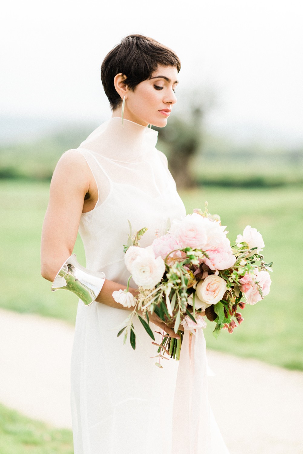 Short haired bride holding a bouquet of flowers