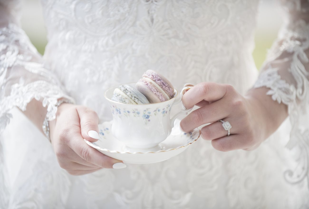 bride holding teacup with macaroons