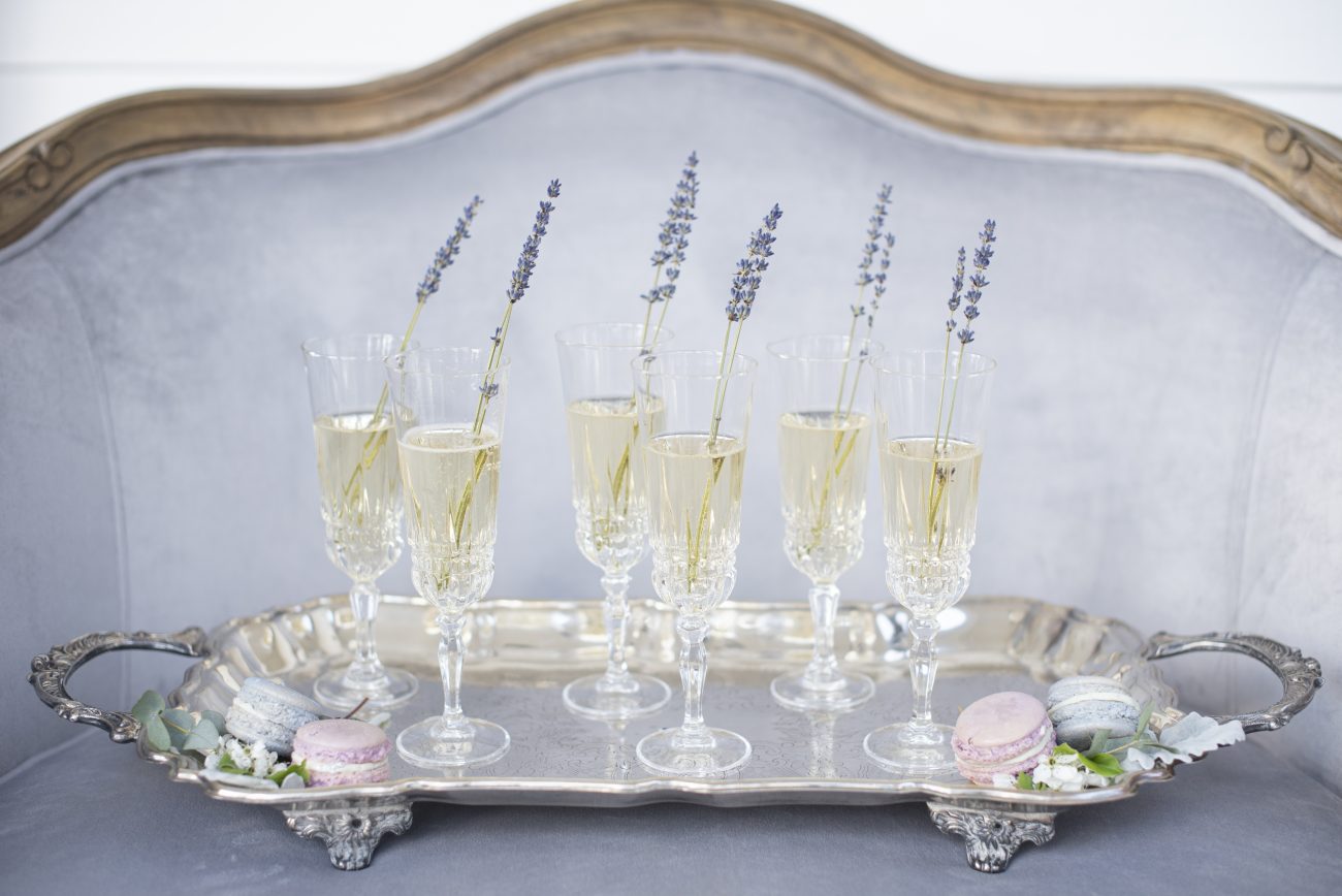champagne glasses on a silver tray with lavener