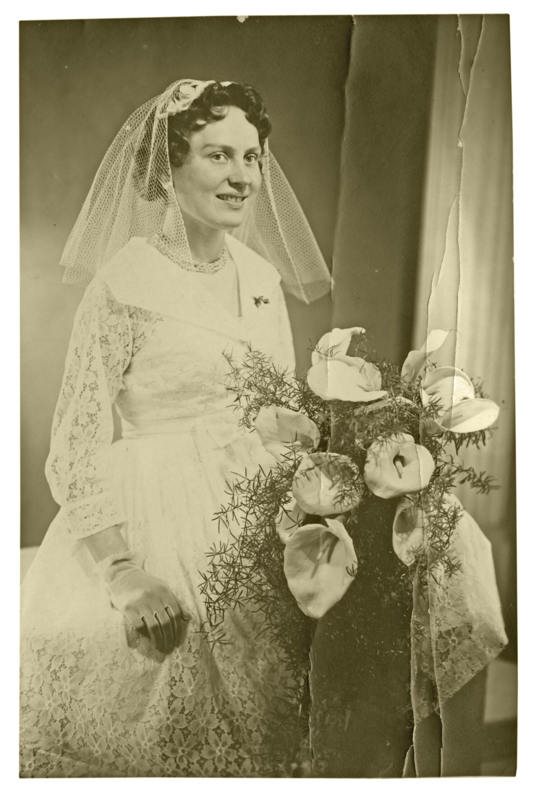 1950s bride wearing long-sleeve lace dress