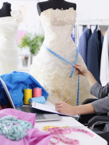 Seamstress measuring a wedding dress