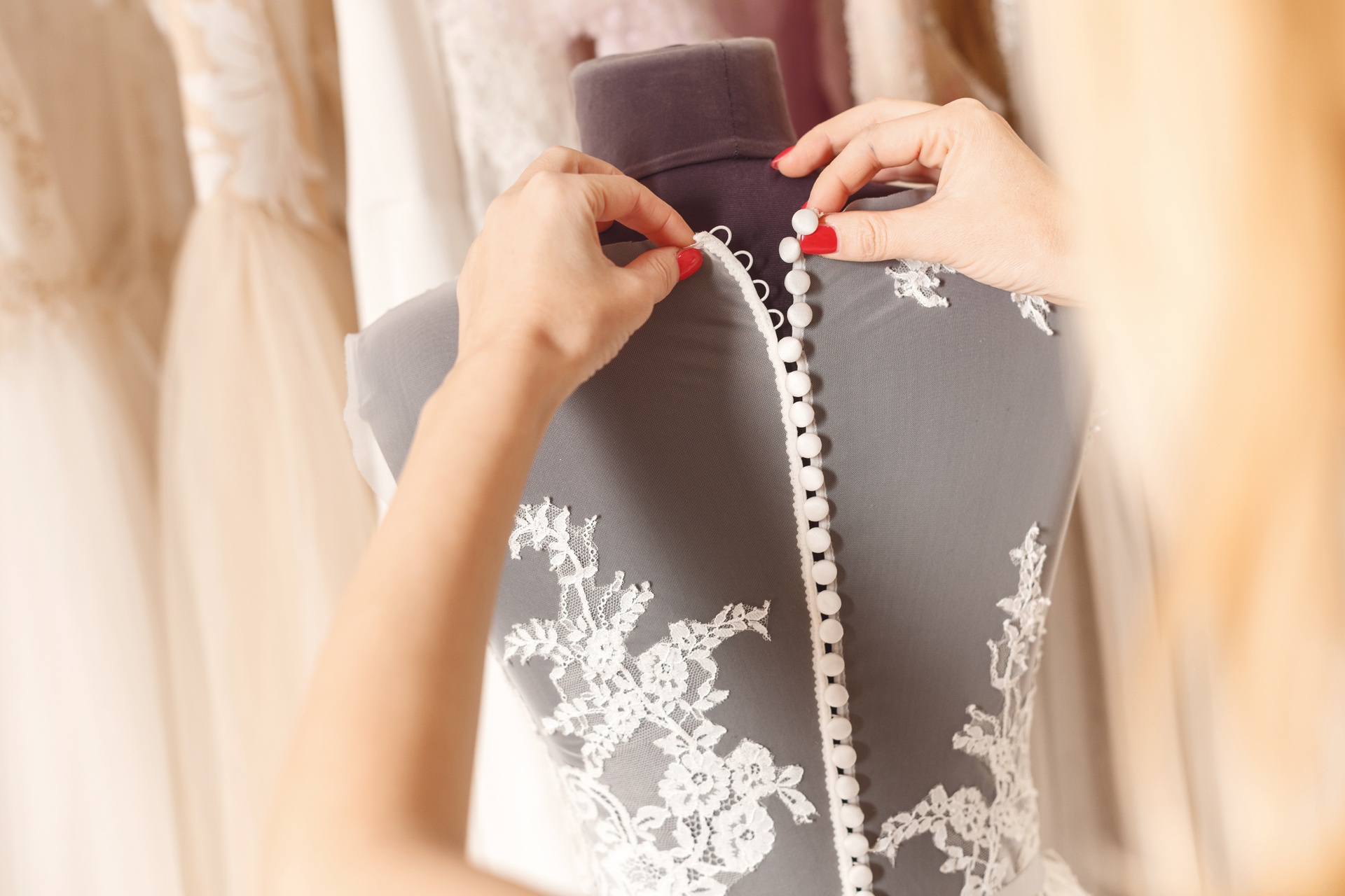 Woman buttoning up the back of a wedding dress