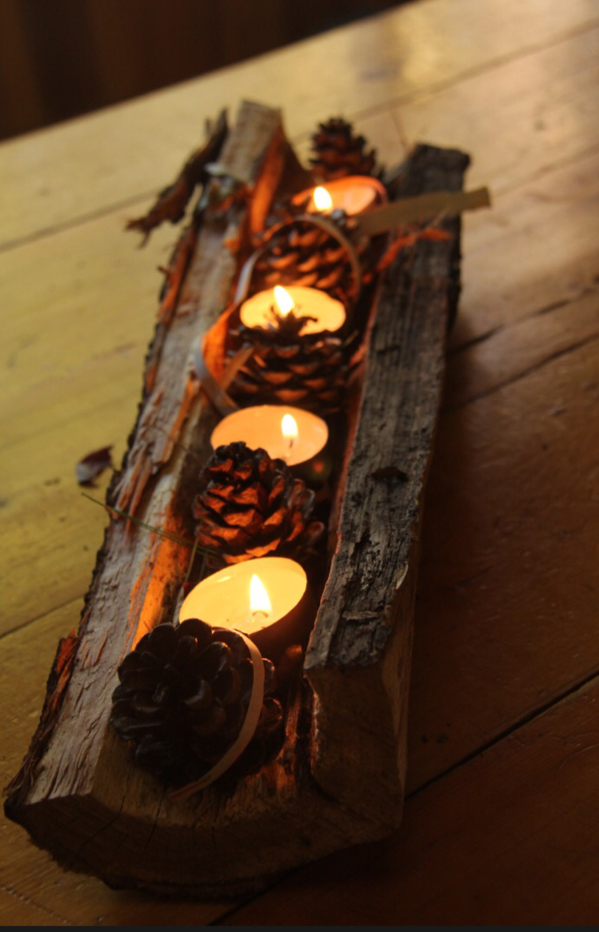 wooden candle holder with pinecones